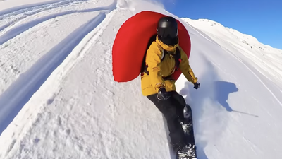 Snowboarder deploys avalanche airbag mid-air to see if it can help him fly