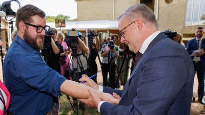 Albanese inks WA tax pledge on reporter's arm