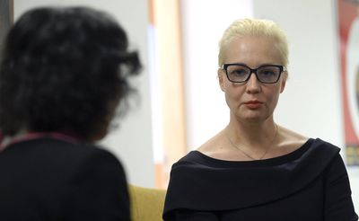 Wife of dead Putin opponent vows fight