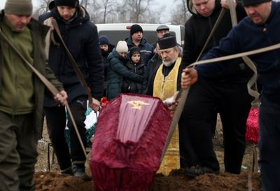 Pale With Grief, A Ukrainian Girl Buries Her Family