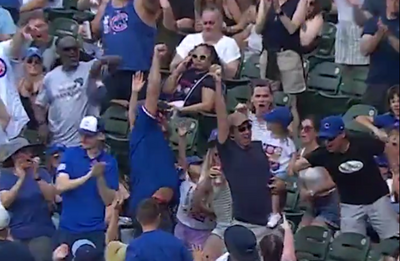 A Cubs fan somehow snagged a foul ball with one hand while holding a child