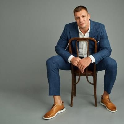 Rob Gronkowski Stuns In Sharp Blue Suit Beside Classic Chair