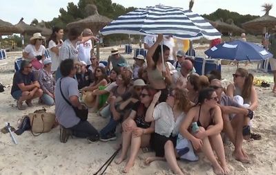 Mallorca locals cram together under one parasol in latest overtourism protest