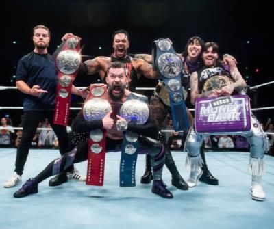 Wrestling Champions Show Off Belts In Impressive Ring Pose