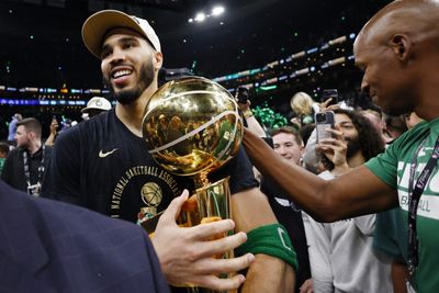 Jayson Tatum and the Boston Celtics carrying the NBA Championship trophy off the court