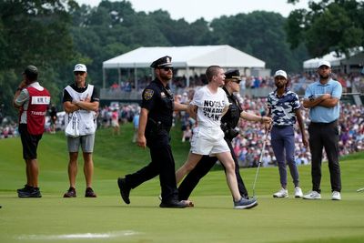 Six protesters run onto 18th green and spray powder, delaying finish of Travelers Championship