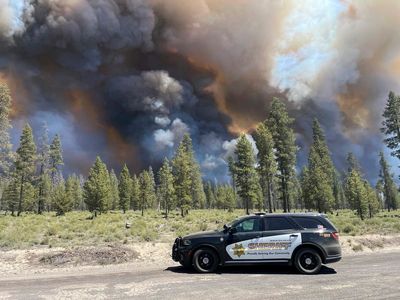 Wind-driven wildfire spreads outside a central Oregon community and prompts evacuations