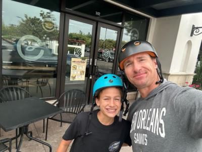Drew Brees And Child Safely Cycling With Helmets On