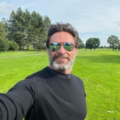 Hugh Jackman Poses In Stylish Black Outfit Surrounded By Greenery