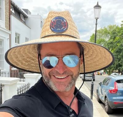 Hugh Jackman's Stylish Outfit: Black Shirt, Beige Hat, Sunglasses