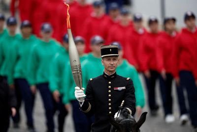 France's Bastille Day parade meets Olympic torch relay as political crisis continues