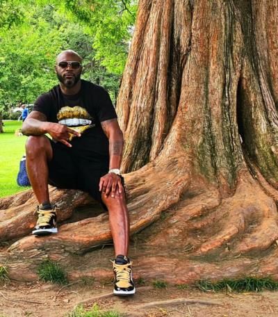 Reggie Wayne Posing Confidently In Black Attire Next To Tree