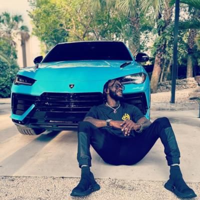 Deontay Wilder Showcasing A Stylish Blue Sports Car