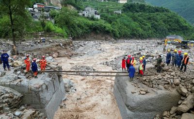 Rescuers search for dozens missing after flooding and a bridge collapse in China kill at least 25