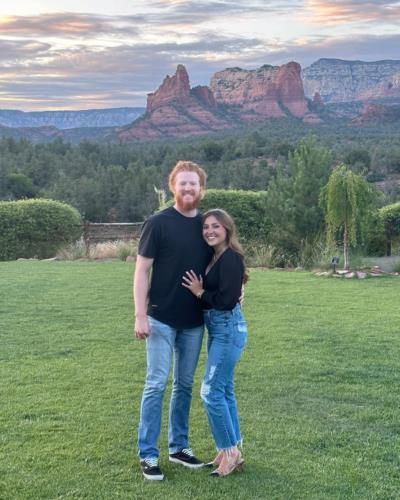 Dustin May And Wife Coordinating Outfits Against Scenic Background