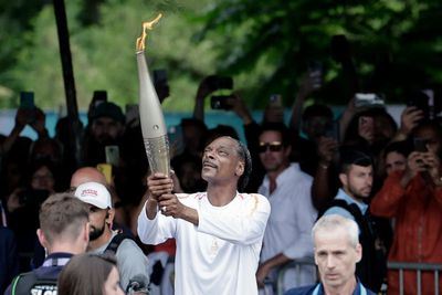 Snoop Dogg carries the Olympic torch before opening ceremony in Paris
