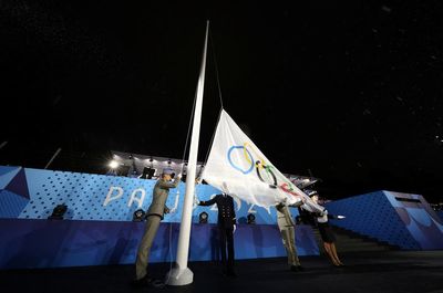 Olympic flag raised upside down at end of rain-soaked opening ceremony