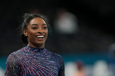 Simone Biles is on the Olympic gymnastics competition floor in front of a star-studded crowd