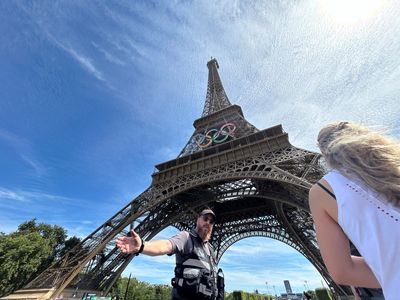 A man is seen climbing the Eiffel Tower, prompting an evacuation hours before closing ceremony