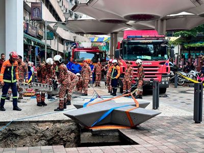 Woman plunges into 8-meter deep hole after pavement sinks in Malaysia