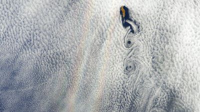 Earth from space: Warped 'double rainbow' glory appears next to rare cloud swirls over Mexican island