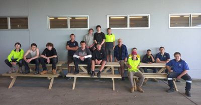 Teens get on the tools to craft picnic tables for the schoolyard