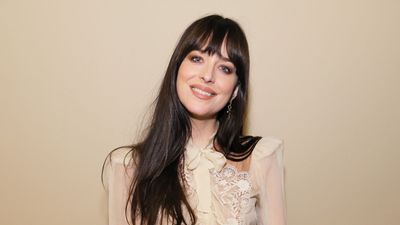 Dakota Johnson's bedroom modernizes a century-old wall feature with textured linens, wicker furniture, and colorful accessories