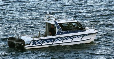 Police commandeer jet ski to rescue fishermen clinging to capsized tinny