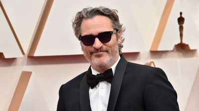 Joaquin Phoenix balances red cabinets with neutral wall tiles – his strategic color tactic makes this controversial hue accessible