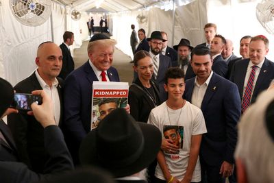 Trump slammed for grinning while holding picture of kidnapped American on October 7 anniversary