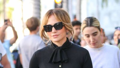 Jennifer Lopez perfects all-black styling - in an elegant tie-neck sweater, tapered pants and the chicest lace-up ballet flats