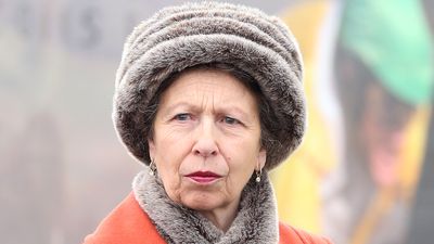 Princess Anne wrapped up warm and chic in burnt orange coat, fluffy hat and mid calf boots for day at the races