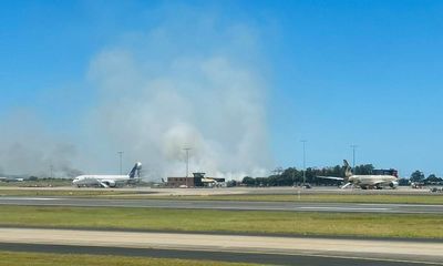 Qantas flight makes emergency landing at Sydney airport after engine failure, sparking grass fire near runway