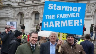 Robert Jenrick poses under ‘Starmer the farmer harmer’ sign at ‘tractor tax’ protest