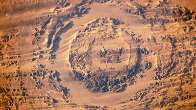 Earth from space: Wandering sand dunes circle gigantic 'eye' sculpted by ancient city-killer meteor in the Sahara