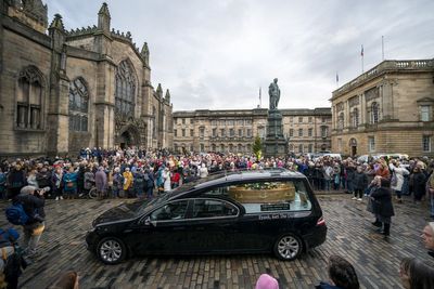 Hearse carrying coffin of Janey Godley showered with roses along Royal Mile