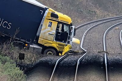 One person in hospital after lorry crashes on to railway line