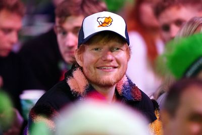 Ed Sheeran watches darts championship wearing cap with hot sauce logo