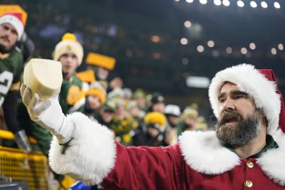 Jason Kelce plays Santa Claus, doling out pieces of cheese at Lambeau Field