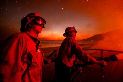 Wildfires latest: Winds subside as firefighters battle devastating blazes in Los Angeles area