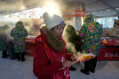 AP PHOTOS: Warm clothing, hot pot and even ice cream bars feature at China's Harbin ice fair