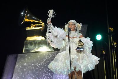 Smatterings of sparkle and color pop amid more subdued tones on Grammys red carpet