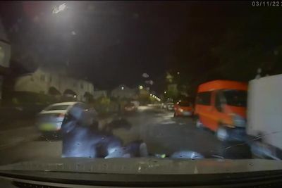 The moment a police car knocks two men off motorbike