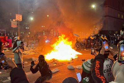 Chaos on Philadelphia streets as Super Bowl fans start fires and climb on cop cars