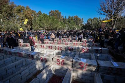 With flowers, tears and defiance, thousands bury nearly 100 Lebanese in mass funeral