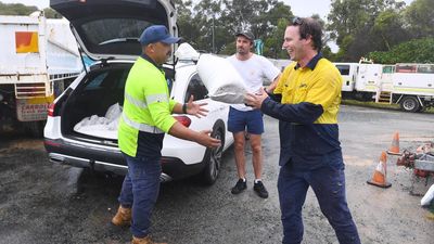 Sun bathing to sandbagging: nervous wait for cyclone