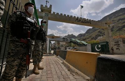 Afghan and Pakistani forces trade fire at the border as a key crossing remains closed