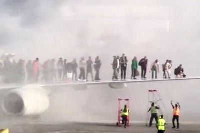 American Airlines passengers scramble onto wing to flee burning engine as plane lands at Denver airport