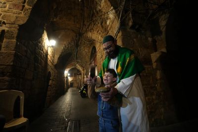 AP PHOTOS: With the bang of his drum, he wakes up the whole neighborhood in a Ramadan tradition