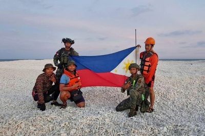 China and Philippines raise flags on tiny South China Sea sandbank as tensions mount